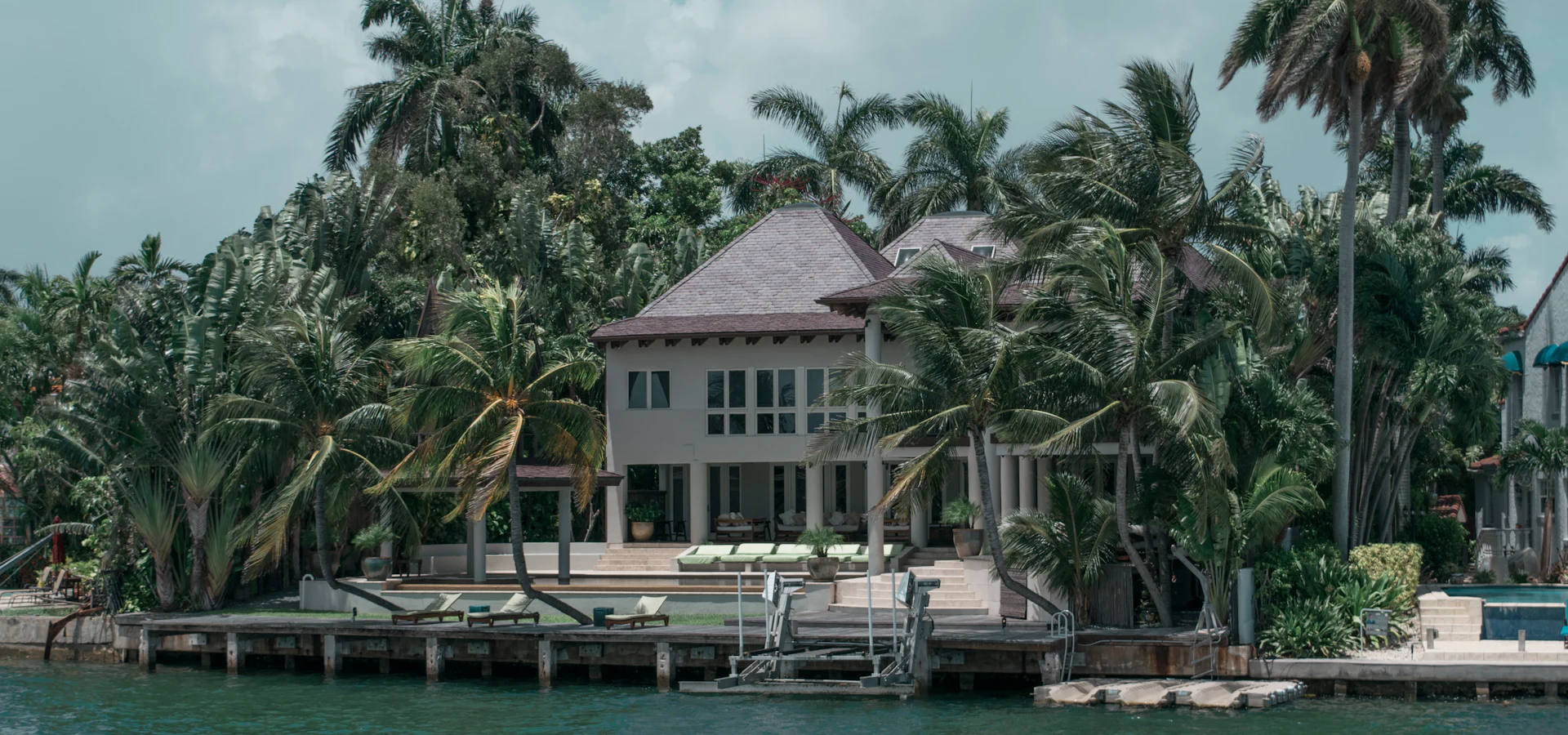 Southwest Florida luxury waterfront home with palm trees and pool