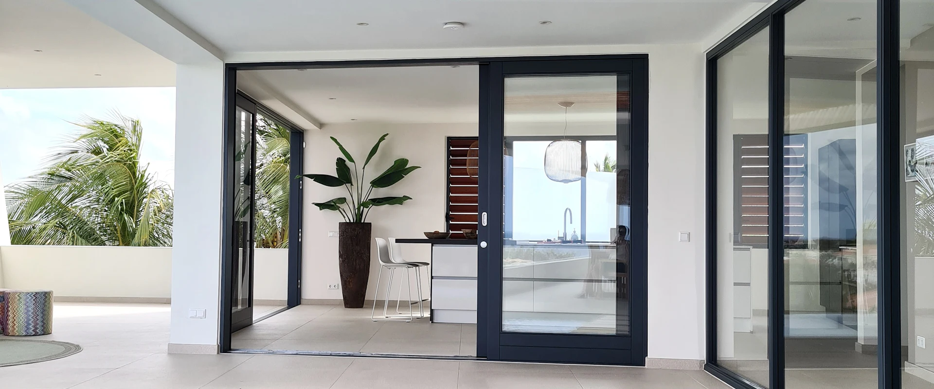 Tropical pool with sliding glass doors open to outdoor living